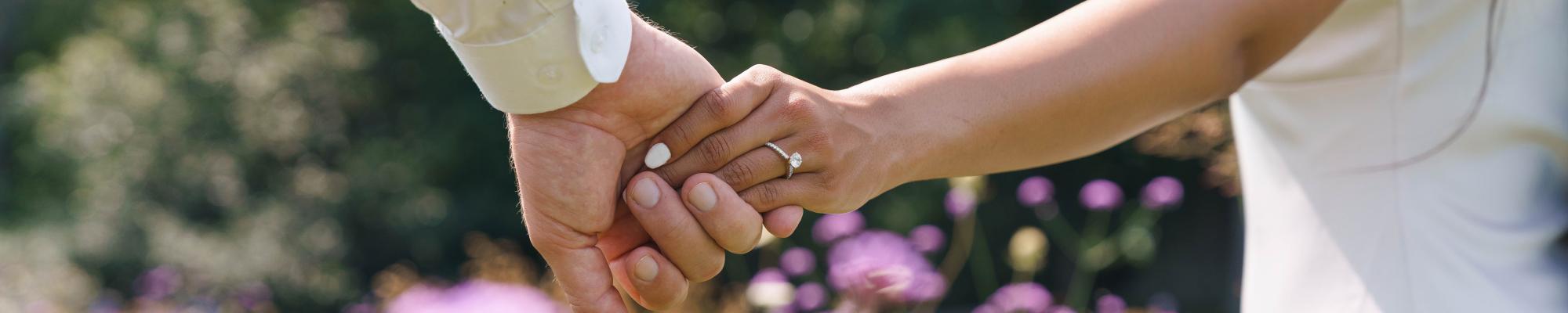 couple holding hands, woman wearing diamond ring