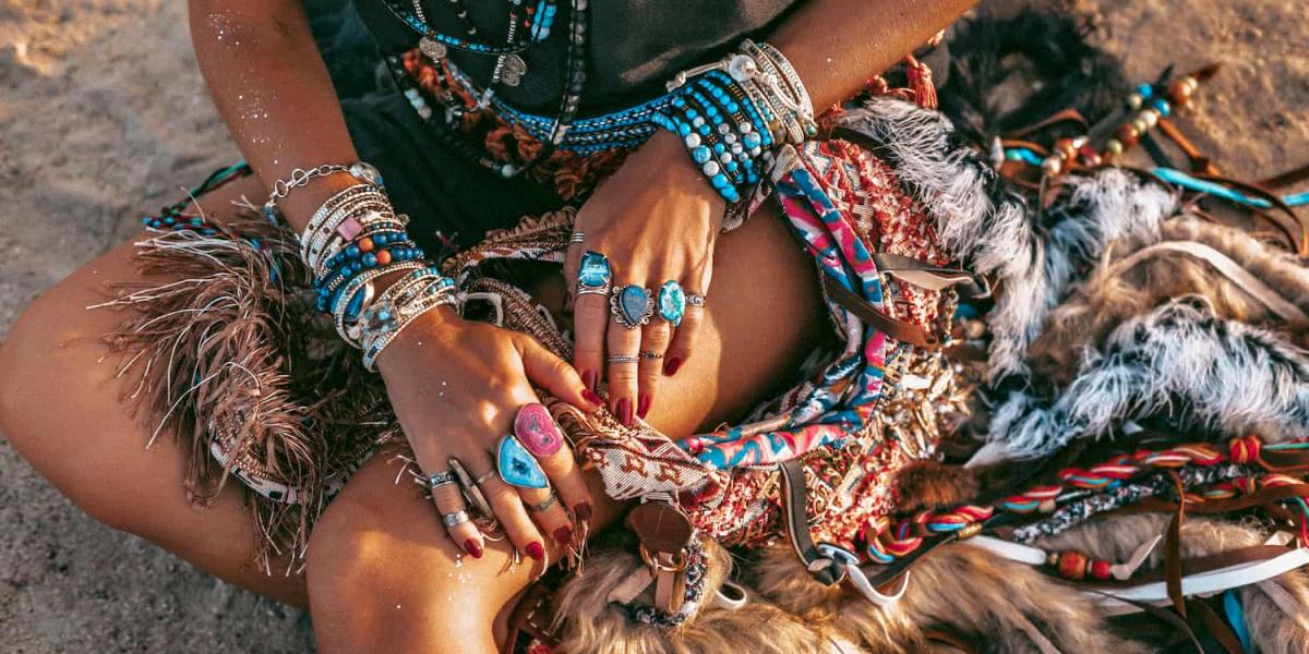 Picture of a person wearing many gemstones jewellery on a beach