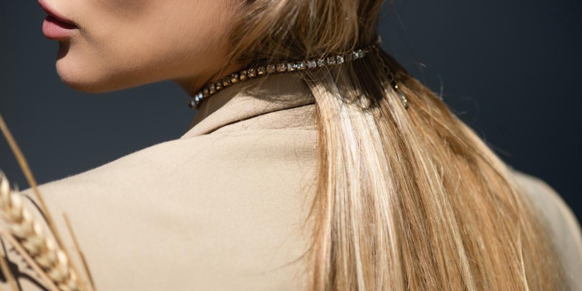 Close-up of a woman wearing a crystal-studded choker necklace, highlighting the fall jewellery trend.